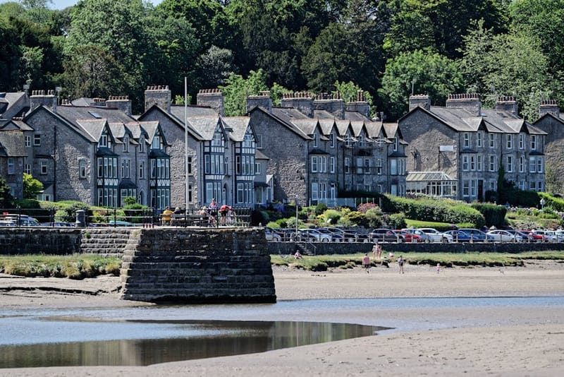 Picturesque view of traditional houses along the promenade in Arnside, with beach and estuary in the foreground.